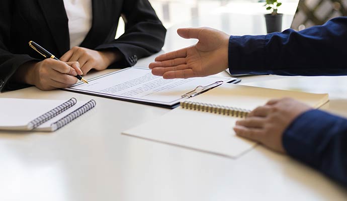A client signs a document at a desk