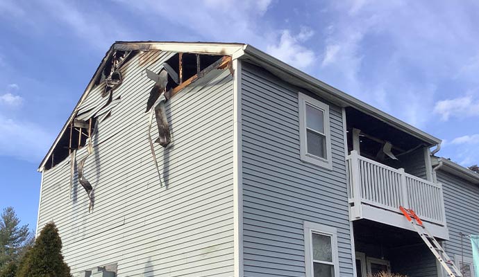A fire-damaged house has a burned roof