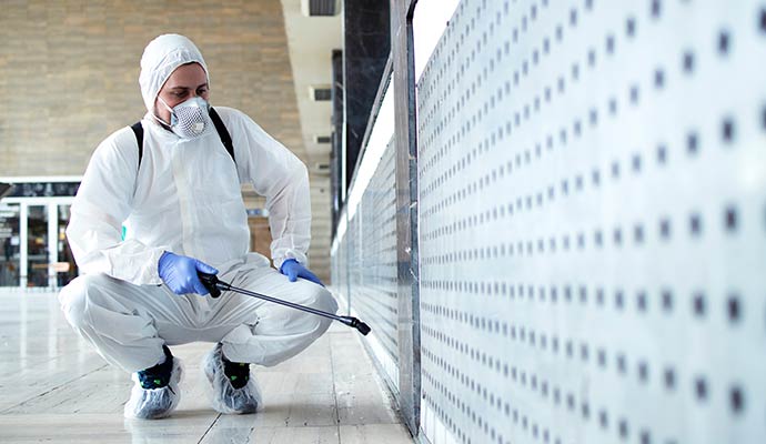 A technician sanitizes a commercial wall