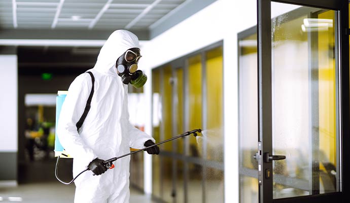 A technician sprays disinfectant in an office