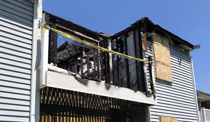 An exterior view of a house showing severe structural fire damage