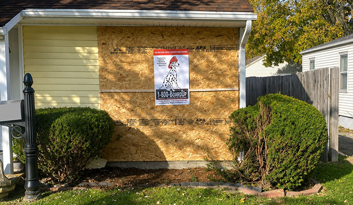 Boarded-up window on a yellow house