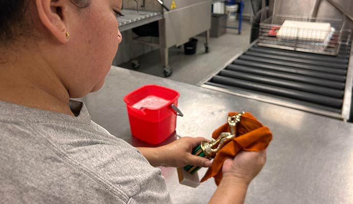 Expert cleaning a trophy during content restoration