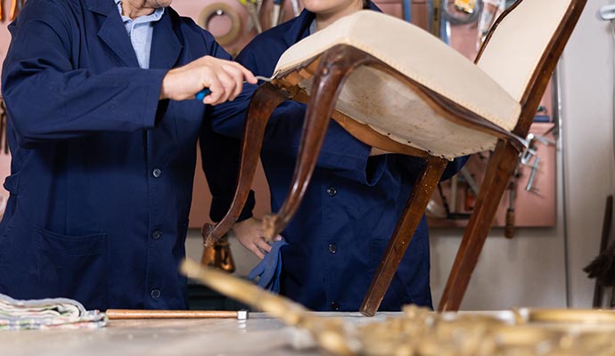 Two persons restoring furniture