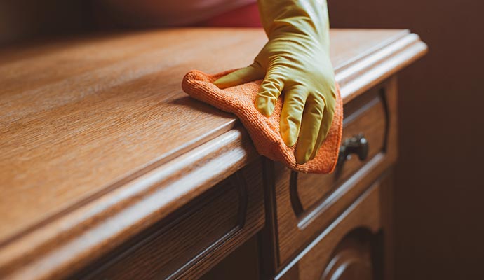 A person polishing wooden furniture