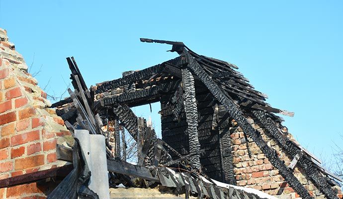 Burned house with structural damage Exterior of a burned residential house with visible structural damage.