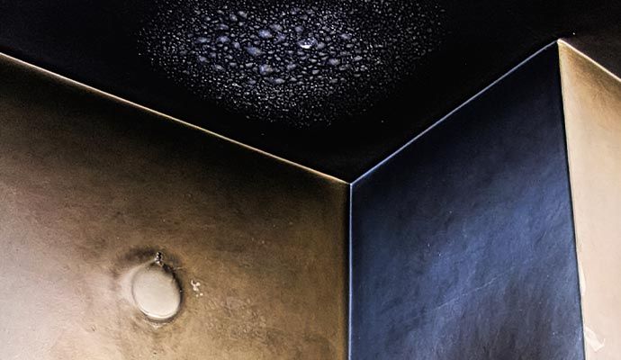 Ceiling surface covered with soot and smoke residue from fire damage.