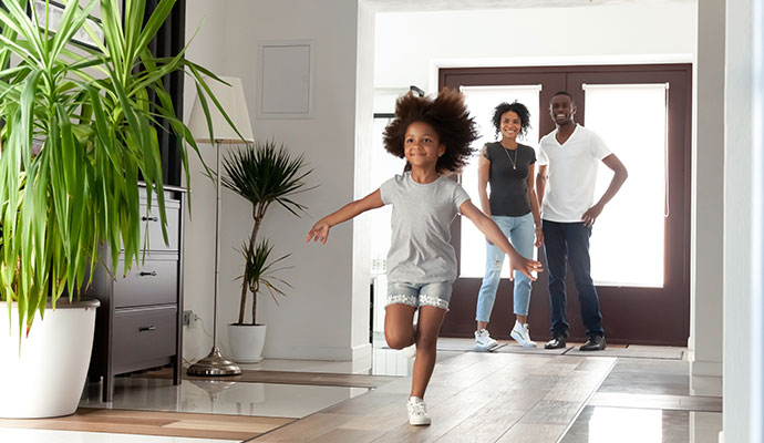 Happy family entering home after restoration service