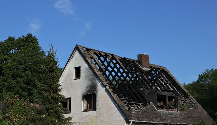 The charred remains of a house roof after a severe fire.