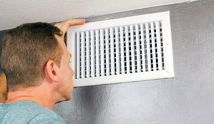 Man checking airflow at a vent