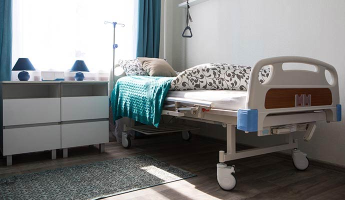 An adjustable hospital bed inside a medical recovery room