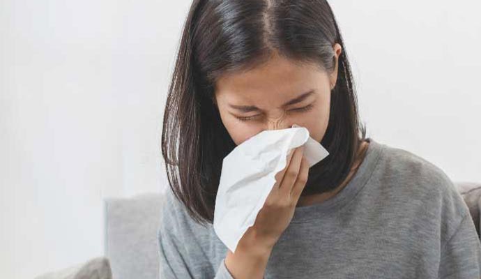 A person holding tissue to her nose