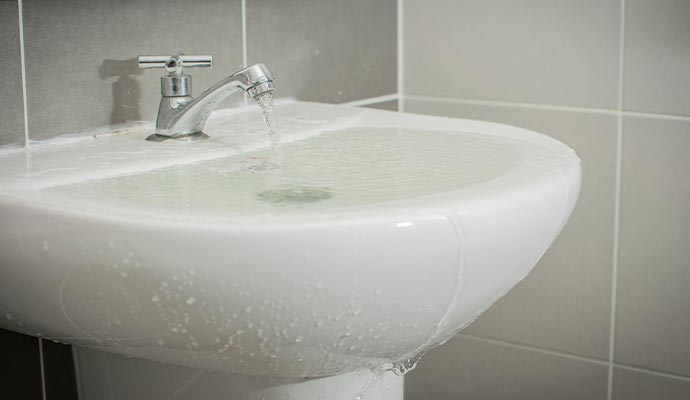 Bathroom sink overflowing with water Bathroom sink overflowing with water