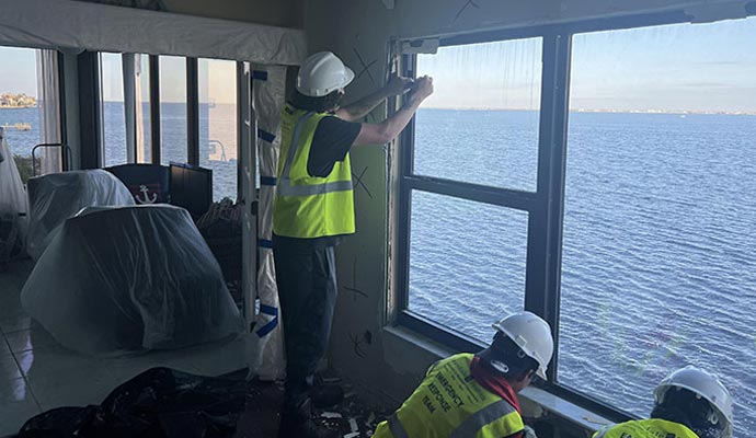 Professional team fixing hurricane damaged window