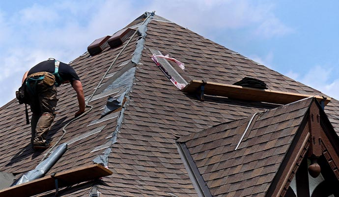 Professional worker repairing roof damage