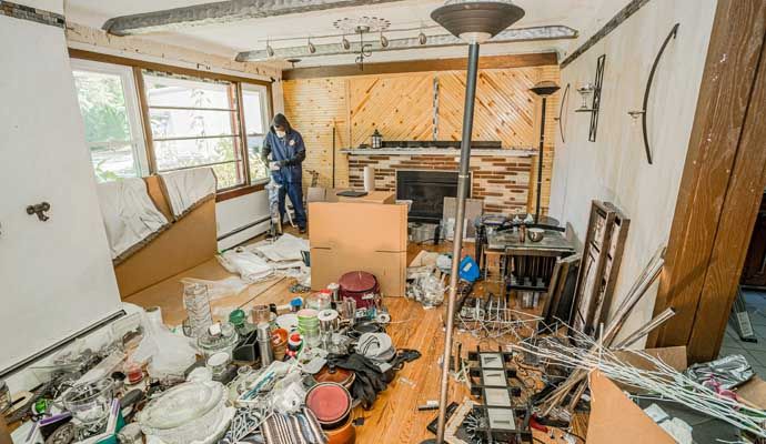 A professional worker is cleaning a hoarded house