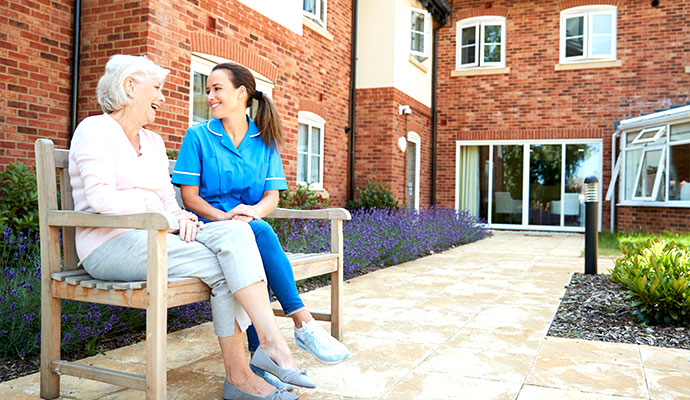 Caregiver and senior sitting outside