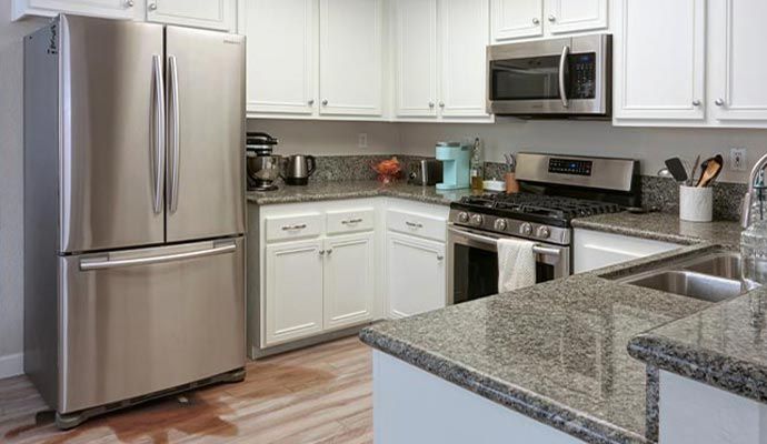 Refrigerator leaking water onto the kitchen floor.
