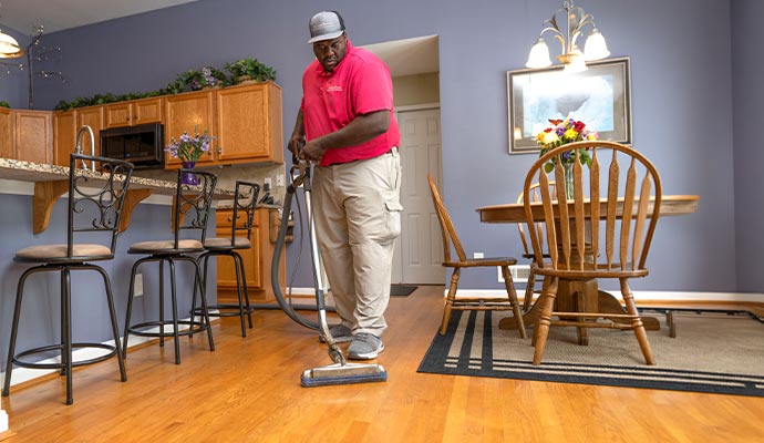 A professional of Teasdale Fenton Cleaning & Property Restoration cleaning wooden floor with equipment